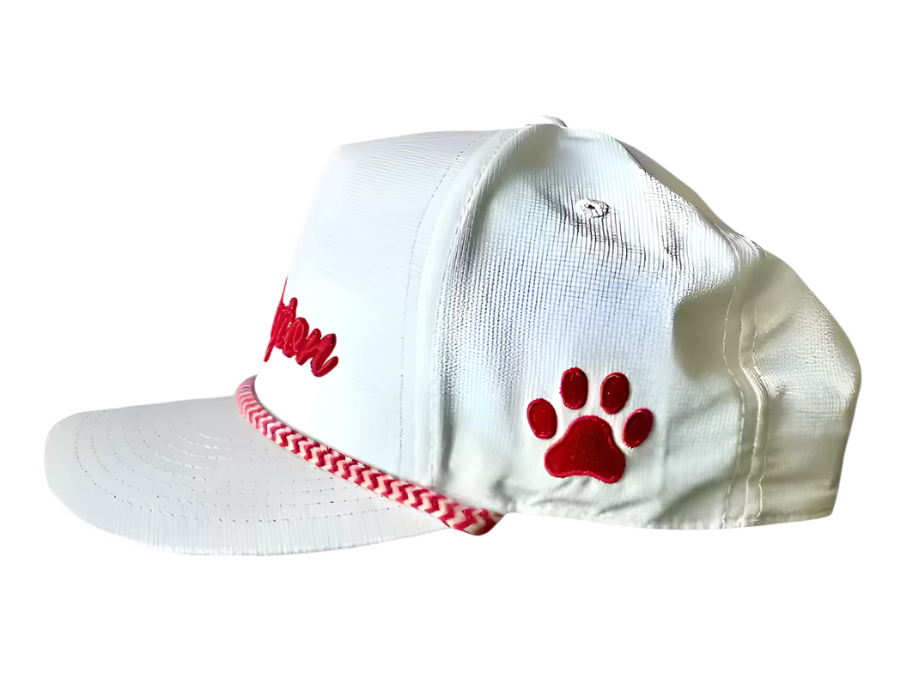 White cap with red paw print and text on a wooden surface